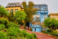 Curvy brick road next to stunning colorful west coast homes