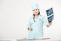 Curvy female doctor standing at table with X-ray examination results, image of skull in hand, wearing medical gown and Royalty Free Stock Photo