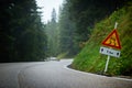 Curvy mountain road with slippery route sign Royalty Free Stock Photo