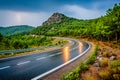 Curvy mountain road during storm with lightning striking in the distance Royalty Free Stock Photo