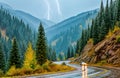 Curvy mountain road during storm with lightning striking in the distance Royalty Free Stock Photo