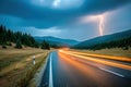Curvy mountain road during storm with lightning striking in the distance Royalty Free Stock Photo
