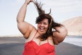 Curvy overweight woman smiling with beach on background - Focus on face