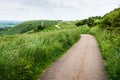 Curvy path on hilly landscape on cloudy day Royalty Free Stock Photo