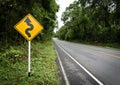 Curvy road sign to the mountain in rural area Royalty Free Stock Photo