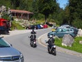 Curvy road with three motorcyclists surrounded by trees in the Alps, Bavaria, Alpenstrasse Royalty Free Stock Photo