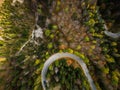 Curvy road trough atumn forest,aerial top down view