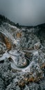 Curvy windy mountain road in snow covered forest, top down aerial view. Winter landscape Royalty Free Stock Photo