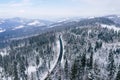 Curvy windy road in snow covered forest, top down aerial view. Winter landscape Royalty Free Stock Photo