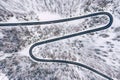 Curvy windy road in snow covered forest, top down aerial view. Winter landscape Royalty Free Stock Photo