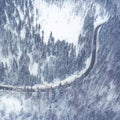 Curvy windy road in snow covered forest, top down aerial view. Winter landscape Royalty Free Stock Photo