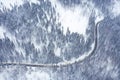 Curvy windy road in snow covered forest, top down aerial view. Winter landscape Royalty Free Stock Photo