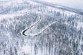 Curvy windy road in snow covered forest, top down aerial view. Winter landscape Royalty Free Stock Photo