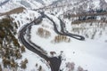 Curvy windy road in snow covered mountain hill. Top down aerial view. Scenic winter background captured from above Royalty Free Stock Photo