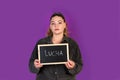 Curvy woman holding a small blackboard with lucha word write in it