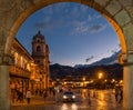 Cusco city at the evening taken inside a stone archway of the colonial historical center.