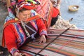 Cusco, Peru - 1 July, 2022: A Quechua lady weaves traditional Andean textiles using alpaca wool