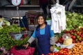 Indigenous young woman smiling and selling vegetables