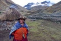 A proud Andean lady stands in front of her farm building in the remote Quesqe Valley. Cusco, Peru