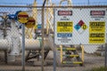 05-14-Cushing USA - Danger and Caution signs at pipeline terminal at tank farm with high fence in front of equipment