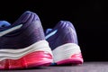 Cushioned running shoes. Female sneakers for run on dark background. Fashion stylish sport shoes, close up