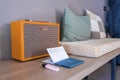 Cushions with antique radio and notepad on wooden table against wall