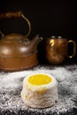 Lemon cake with powdered sugar on dark background with copper tea pot and mug Royalty Free Stock Photo