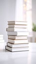 Stack of books on a white table in a bright room with blurred background Royalty Free Stock Photo