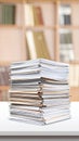 Stack of documents on a white table in a light-filled office setting Royalty Free Stock Photo