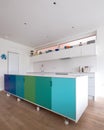 Custom designed kitchen island in open plan kitchen on industrial castor wheels, retro design painted in blue and green colours. Royalty Free Stock Photo