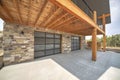 Custom home garage exterior with stone walls and double glass garage doors Royalty Free Stock Photo