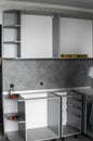 Custom kitchen cabinets installation without a furniture facades mdf. Gray modular kitchen from chipboard material on a Royalty Free Stock Photo