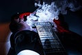 Custom red and black electric guitar with smoke effect, centered against a dark background. m Royalty Free Stock Photo