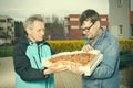 Customer assuming a pizza food from a delivery man on sidewalk Royalty Free Stock Photo