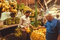 Customer and bananas seller bargain on farmers fruit market