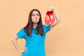 Unhappy Woman Holding a Pair of Red Sport Shoes Royalty Free Stock Photo
