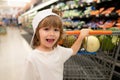 Customer child holdind trolley, shopping at supermarket, grocery store. Little boy in the supermarket. Cute boy child Royalty Free Stock Photo