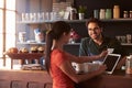 Customer In Coffee Shop Paying Using Digital Tablet Reader Royalty Free Stock Photo