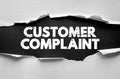 CUSTOMER COMPLAINT text concept under torn paper represents service, communication, business feedback, quality management, and Royalty Free Stock Photo
