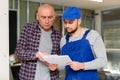 Customer discussing list of tasks with builder in house under renovation Royalty Free Stock Photo