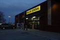 Customer entering the front door of a Dollar General at dusk.