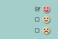 Customer evaluation or positive feedback concept rating. Check mark to select happy smile face on pastel green background.