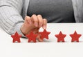 Customer experience feedback concept. Five red stars, the best rating of excellent services with a female hand to meet. White Royalty Free Stock Photo