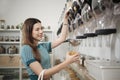 A customer fills cereal foods in a glass jar in a refill retail store