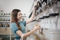 A customer fills cereal foods in a glass jar in a refill retail store