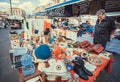 Customer of a flea market looking for shoes and home decor at vintage stuff stands