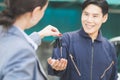 Customer giving car keys to their auto mechanic in auto repair shop, Car repair and maintenance concepts Royalty Free Stock Photo