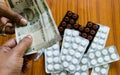 Customer giving money to buy drug at drugstore pharmacy. Close up view. Various capsules, tablets, Pills in medicine shop on table Royalty Free Stock Photo