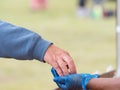 A customer hand places money in a blue hygiene gloved hand worn to avoid transmission and cross infection