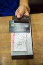 Customer handed the credit card on bill paper, in leather black bill reciept.